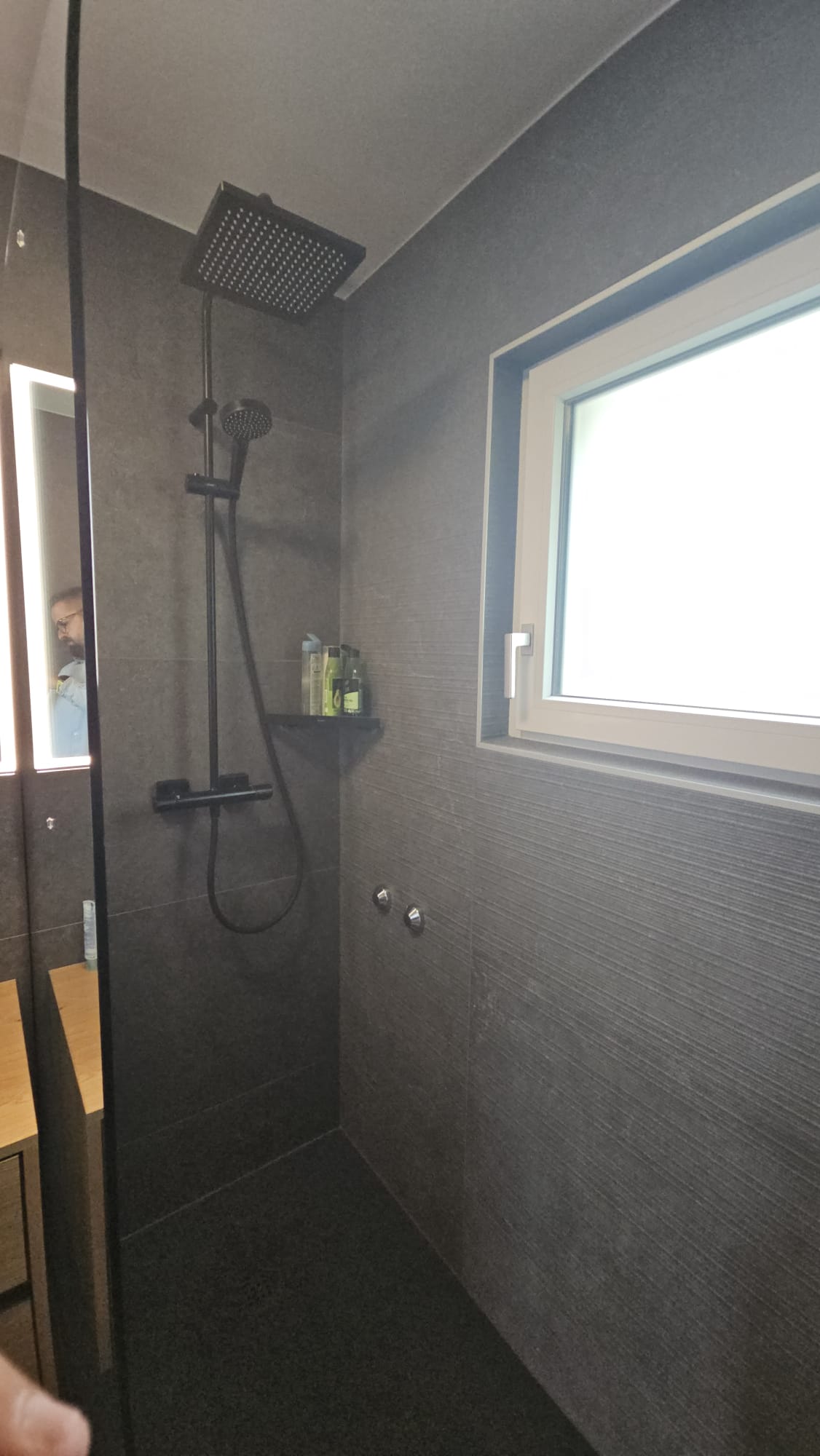 Douche à l'italienne avec robinetterie noire et carrelage gris