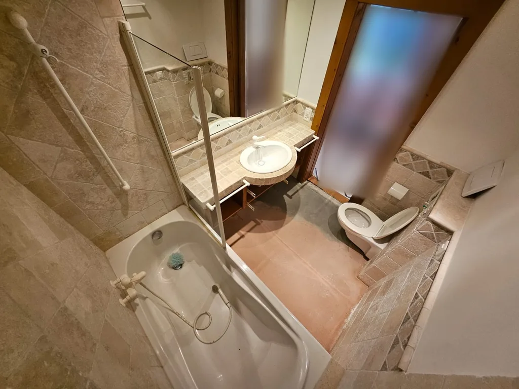 Ancienne salle de bain à Crans-Montana avec baignoire, avant rénovation