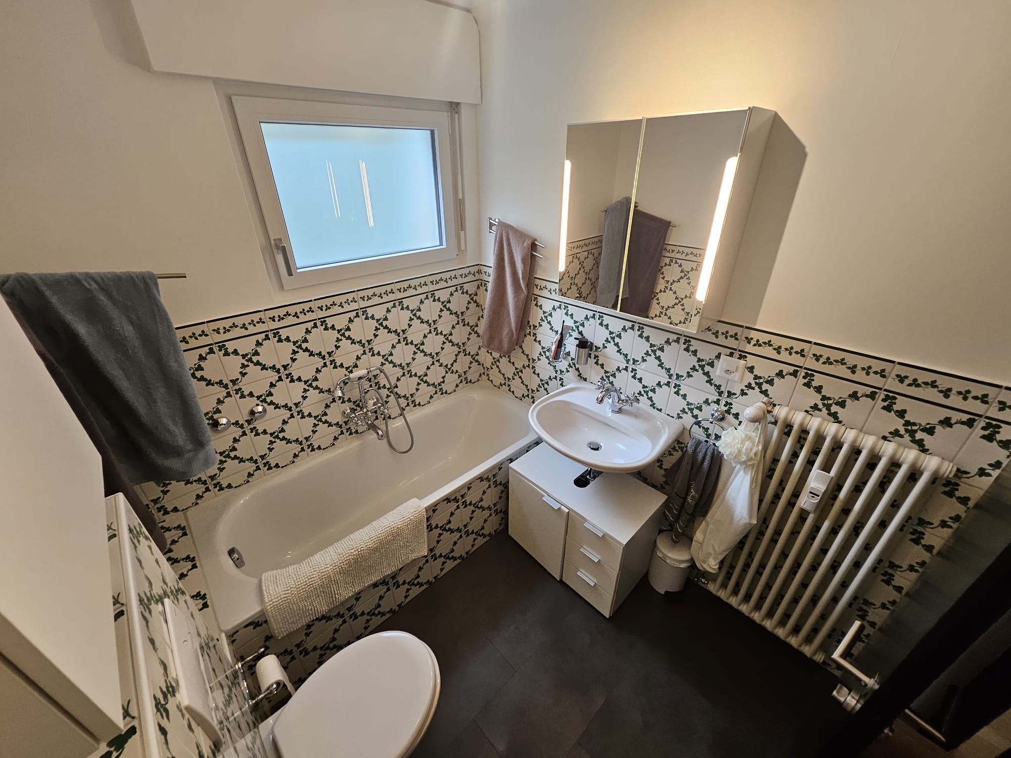 Salle de bain avant rénovation, carrelage mural à motifs